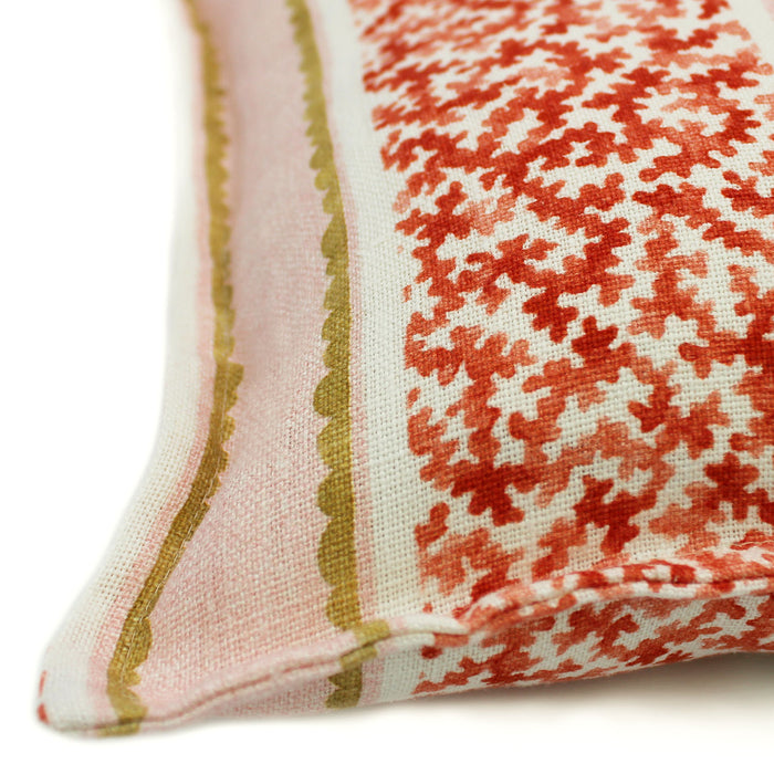 A red, pink and yellow linen cushion with a stylised coral pattern.