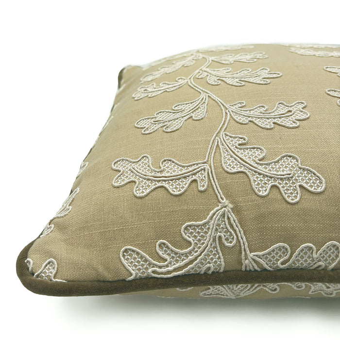 Decorative sand coloured cushion with a off-white leaf pattern.