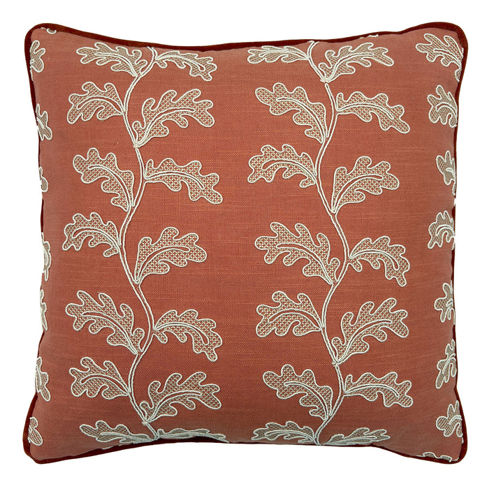 Decorative coral cushion with a off-white leaf pattern.