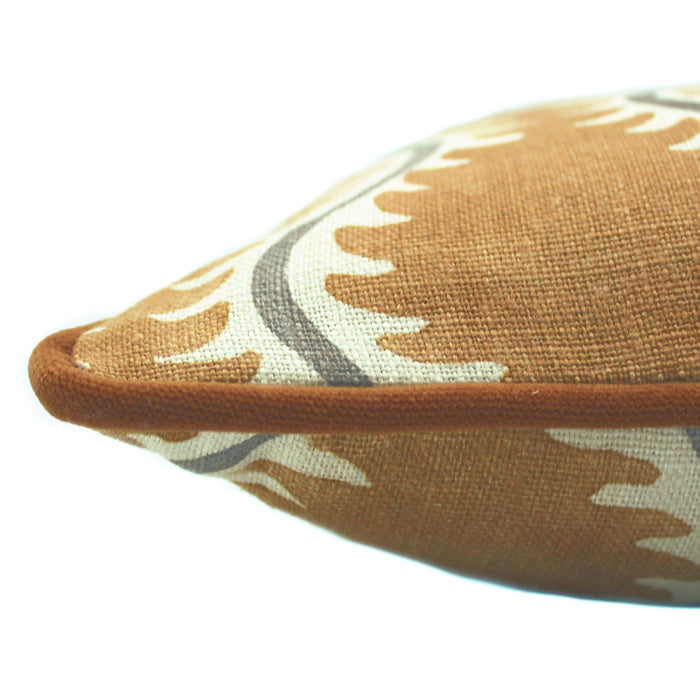 A mustard, grey and brown linen cushion with a all-over repeat pattern and velvet piping.