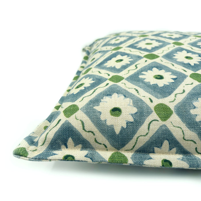 Decorative cushion with a geometric floral pattern in blue and green.
