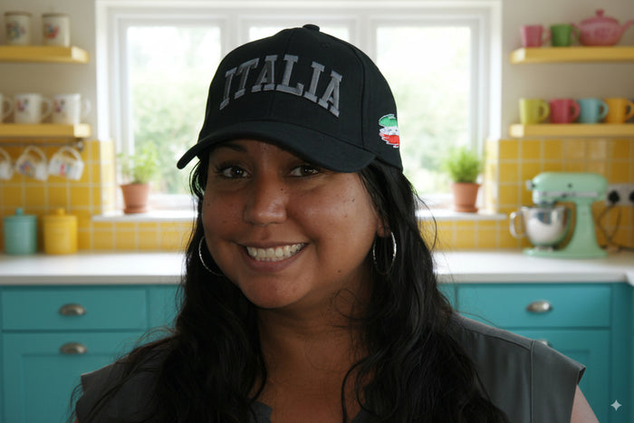 Woman wearing a black cap with 'ITALIA' in a kitchen setting