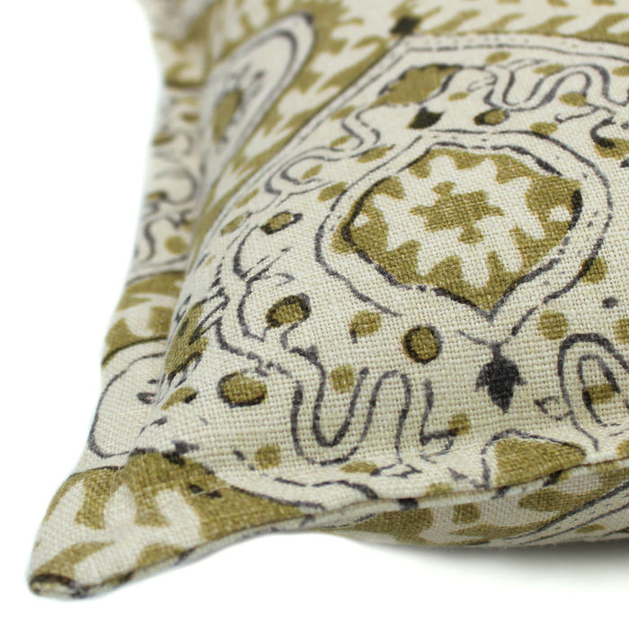 A green, cream and black linen cushion with a central motif pattern.