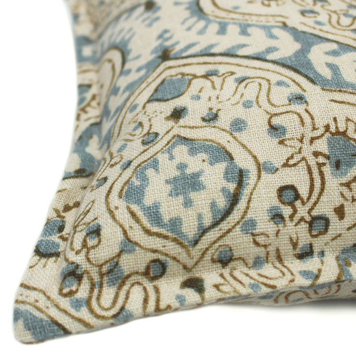 A blue, cream and brown linen cushion with a central motif pattern.