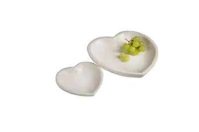 A large, heart-shaped decorative bowl carved from a solid piece of white marble with subtle natural veining and a smooth, polished finish.