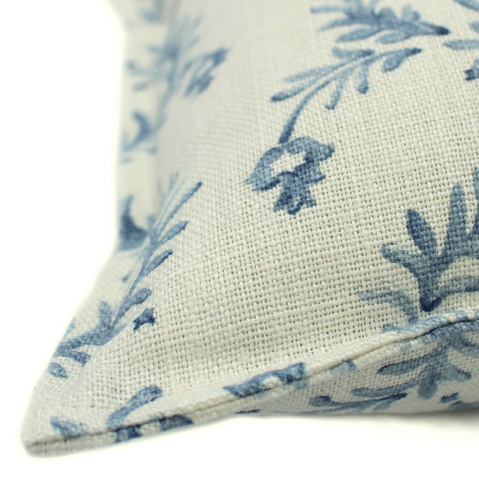 A blue and cream linen cushion with a marine-style pattern.