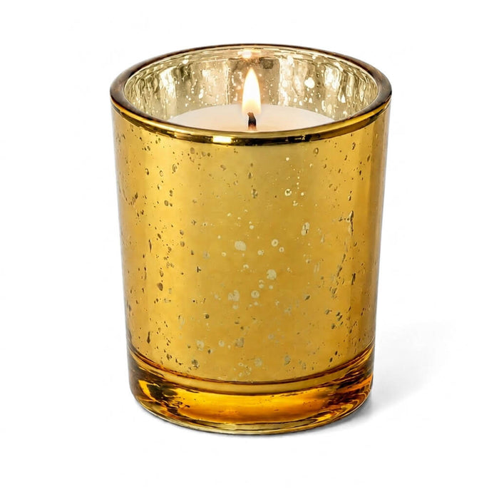 An Amber Gold Mercury Votive Holder with lit candle on a white background