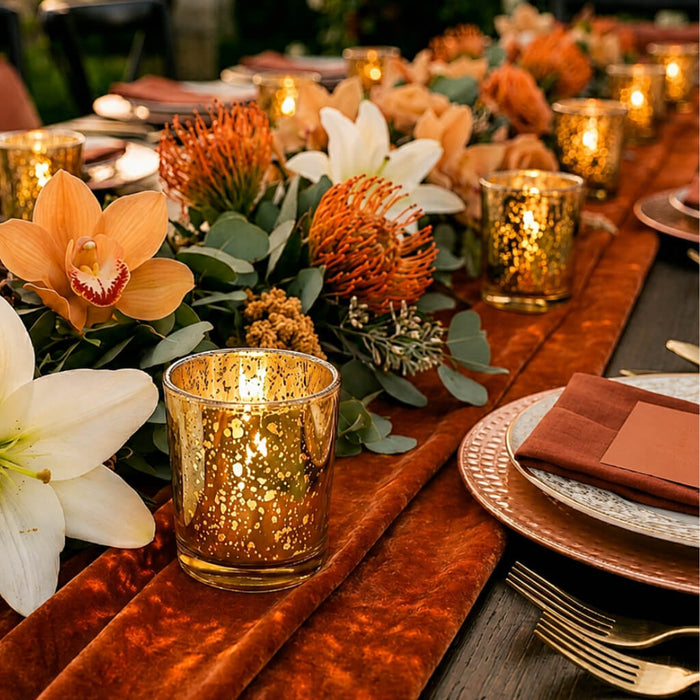 Amber Gold Mercury Votive Holders on a terracotta velvet runner with lilies and pincushions