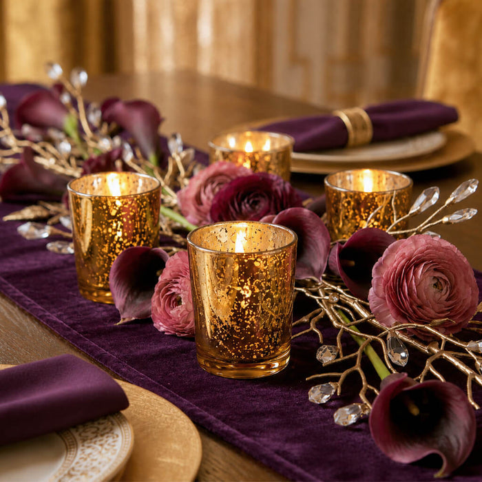 Amber Gold Mercury Votive Holders with lit candles on a plum runner with calla lilies