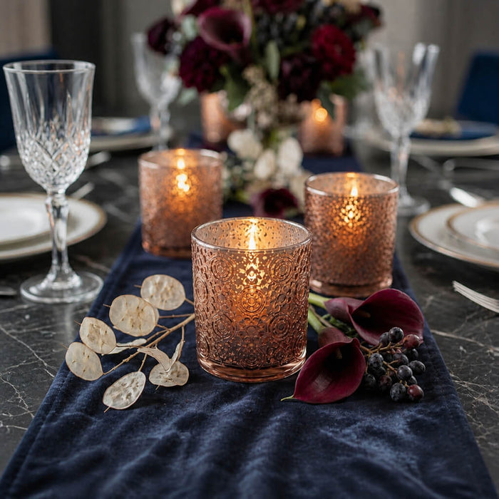 Rose gold mercury candle holders on elegant navy floral dinner table centerpiece