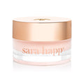 Jar of sara happ lip balm with a gold lid on a white background