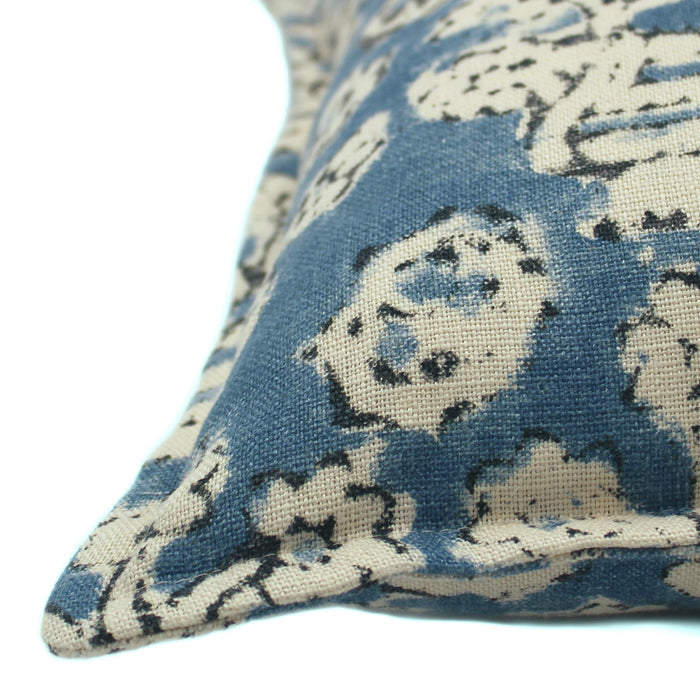 A blue, cream and black linen cushion with a block print pattern.