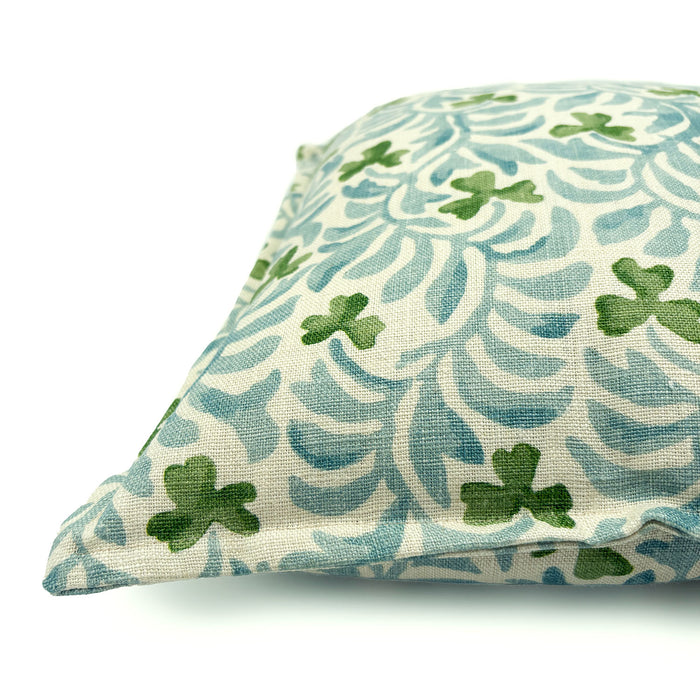 Decorative cushion with a pale blue and green floral pattern.